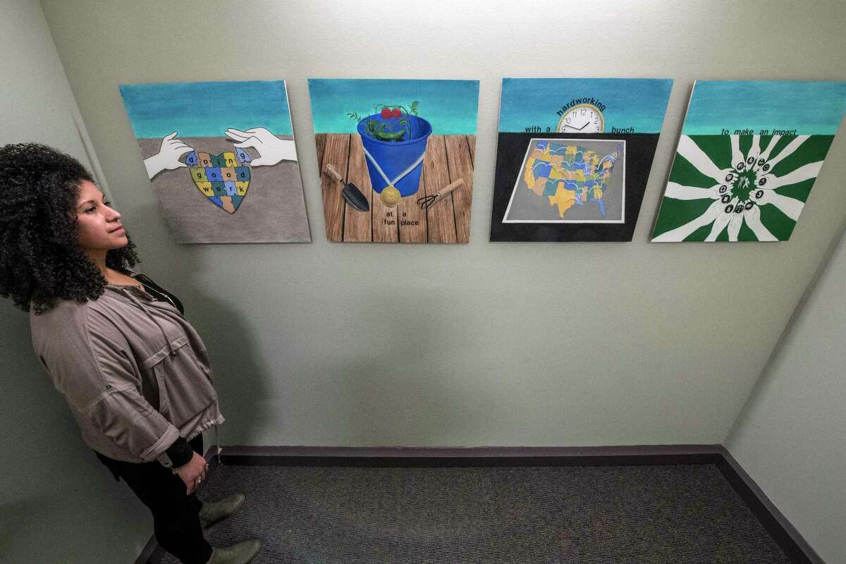 Crystal Brandow shows of some of the artwork on display at the Policy Research Associates Thursday March 15, 2018 Delmar, N.Y. (Skip Dickstein/Times Union)
