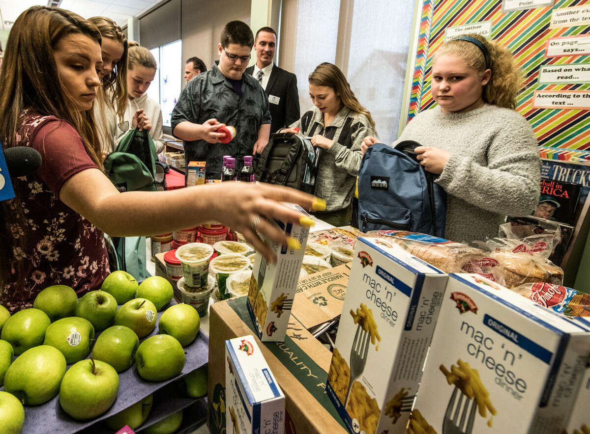 Student Hailey Fisk, 19, left, fills a backpack with food as part of the BackPack Program at Heatly School, which provides students in need with healthy food on the weekends and school breaks. (Skip Dickstein/Times Union)