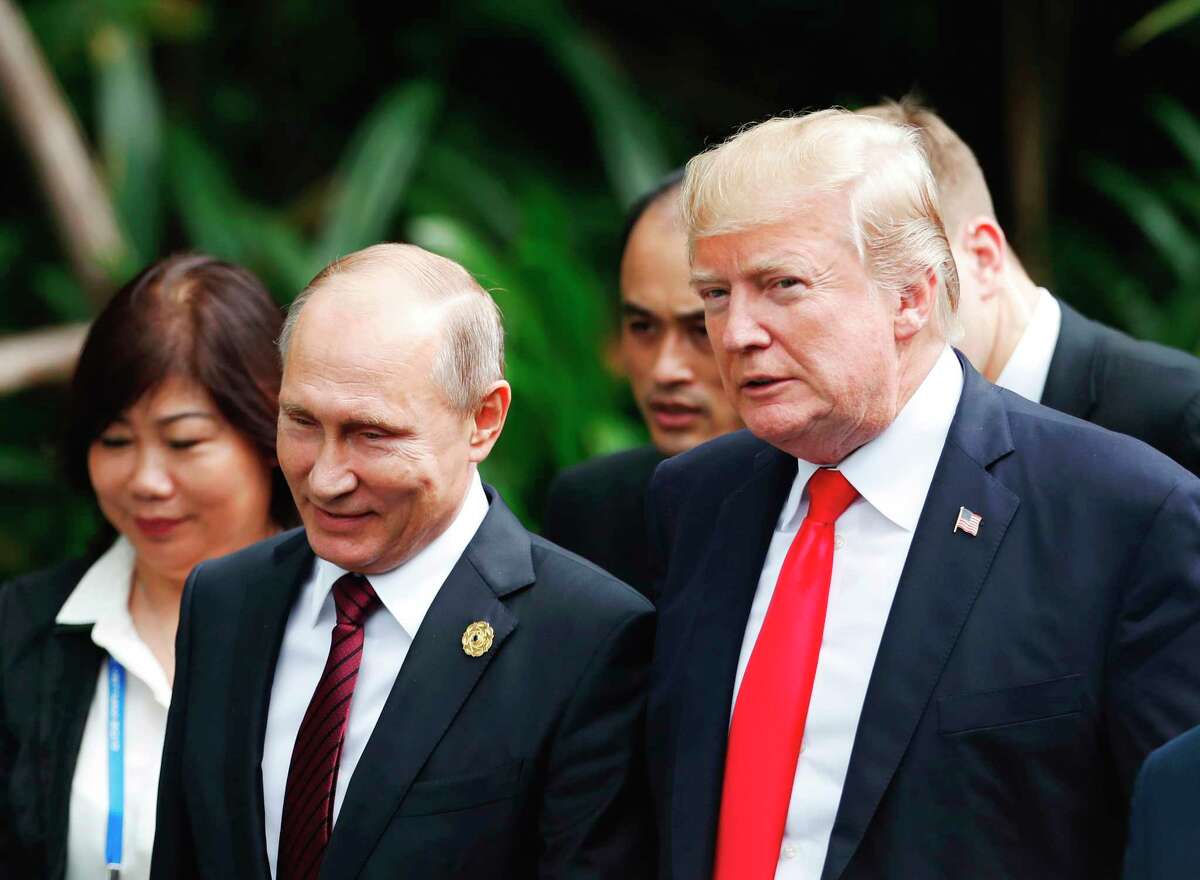 FILE - In this Saturday, Nov. 11, 2017 file photo, U.S. President Donald Trump, right, and Russia's President Vladimir Putin, center, talk during the group photo session at the APEC Summit in Danang, Vietnam. The White House has confirmed that U.S. President Donald Trump invited Russia's Vladimir Putin to Washington. Press Secretary Sarah Huckabee Sanders said Monda, APril 2, 2018 that the White House was among "a number of potential venues" Putin and Trump discussed during a March 20 telephone conversation. (Jorge Silva/Pool Photo via AP, File)