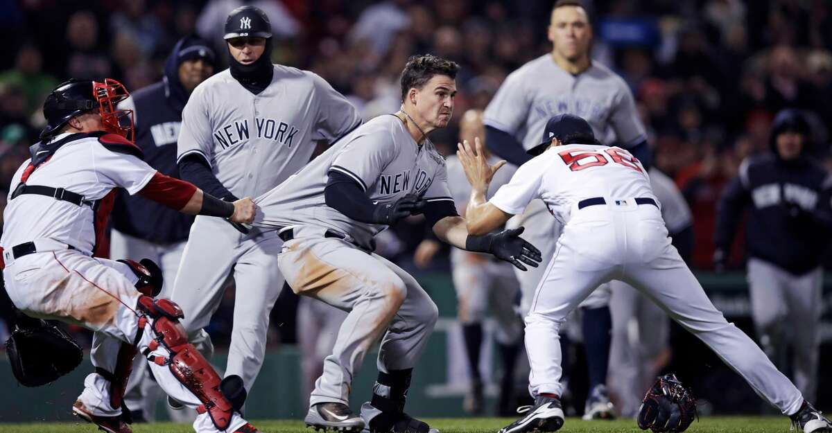 New York Yankees' Tyler Austin, center, rushes Boston Red Sox relief pitcher Joe Kelly, right, after being hit by a pitch during the seventh inning of a baseball game at Fenway Park in Boston, Wednesday, April 11, 2018. At left holding back Austin is Red Sox catcher Christian Vazquez. (AP Photo/Charles Krupa)