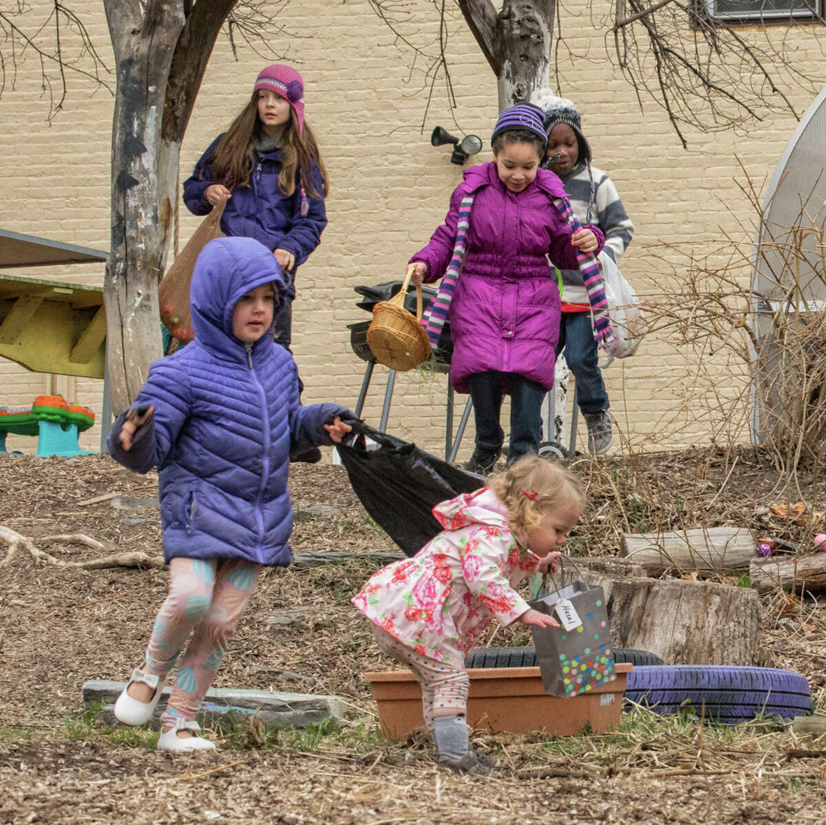 Children and their parents turned out on Easter Sunday for an egg hunt at Gabi?s Community Garden on the corner of Wilbur and Grand streets in Albany?s Mansion Neighborhood. Caleb Tenerowitz, top right, is equipped with a big basket as he waits for the hunt to start. Above, four girls and a boy are on the move looking to fill their baskets and bags with plastic eggs holding chocolate and other treats. Elke van der Laan, at right, smiles with a full basket. Lily Mercogliano and David Easton organized the event with the help of their neighbors. A fine time was had by all despite the cold and rainy weather.