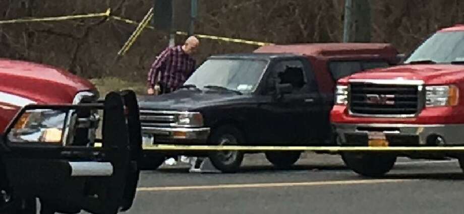 Behind the crime tape in New Milford a pickup truck with its driverside window blown out. Photo: /