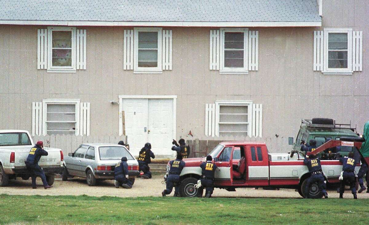 Federal Alcohol Tobacco and Firearms agents approach the front door of the Branch Davidian compound near Waco, Texas, in this Feb. 28, 1993, file photo, in an attempt to serve a search warrant. Four agents and five Davidians were killed in the shootout that marks its 10-year anniversary this month. (AP Photo/Waco Tribune Herald, Rod Aydelotte, File)