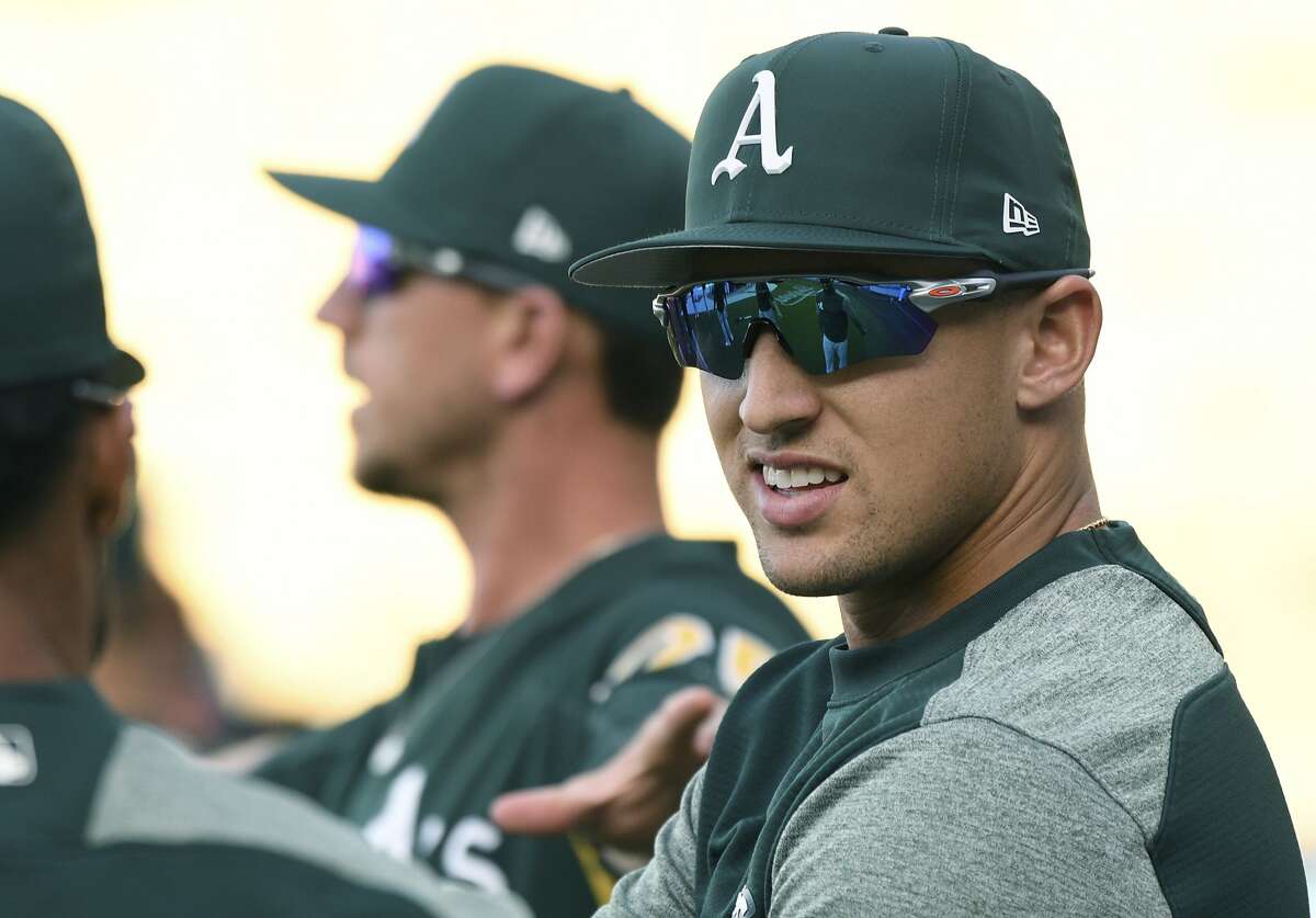 Oakland Athletics' Trayce Thompson, right, warms up for batting practice before a baseball game against the Los Angeles Dodgers, Tuesday, April 10, 2018, in Los Angeles. (AP Photo/Michael Owen Baker)