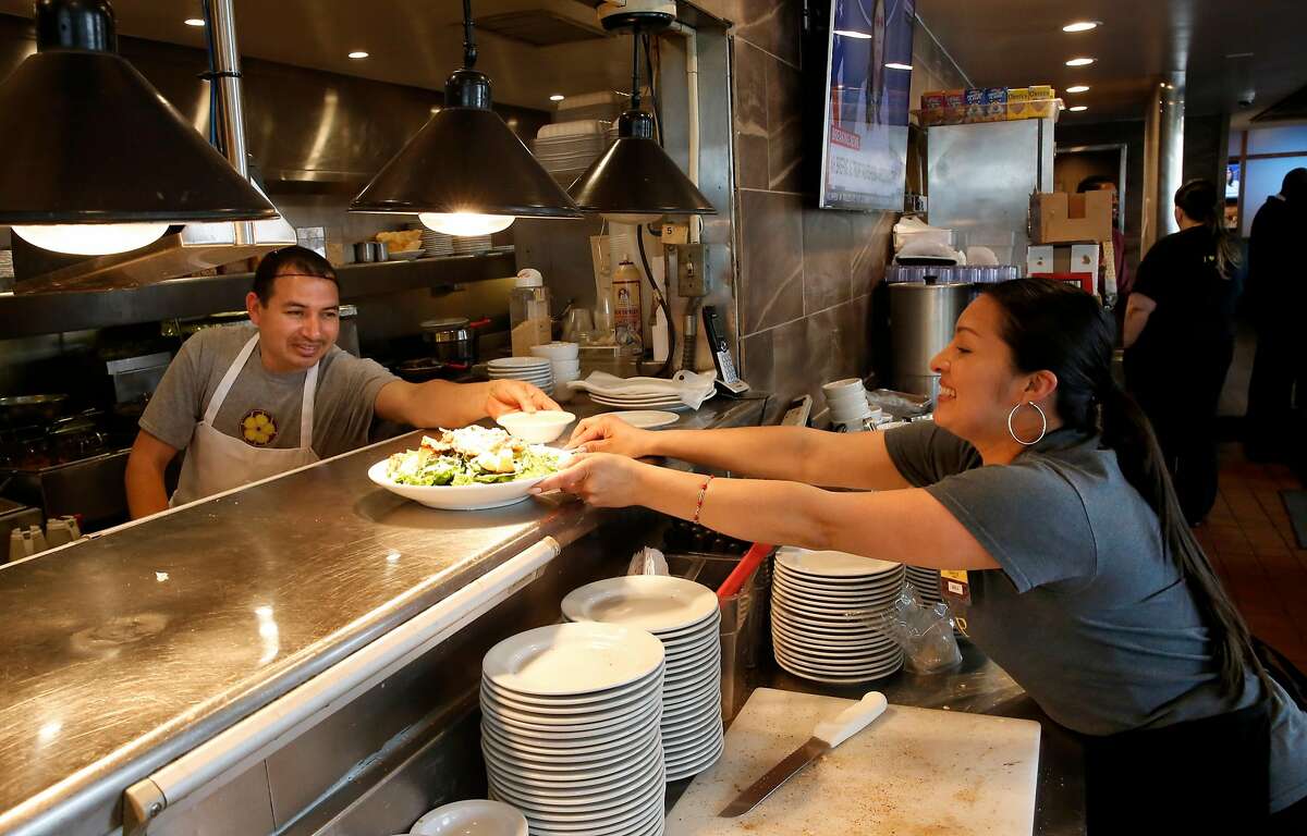 Line cook Victor and server Maricruz work the lunchtime crowd at the Buttercup Diner in downtown Oakland, Calif. on Wed. April 11, 2018. A new federal law about to go into effect would allow tips to be shared with cooks and dishwashers, could change the way the restaurant industry in California operates.