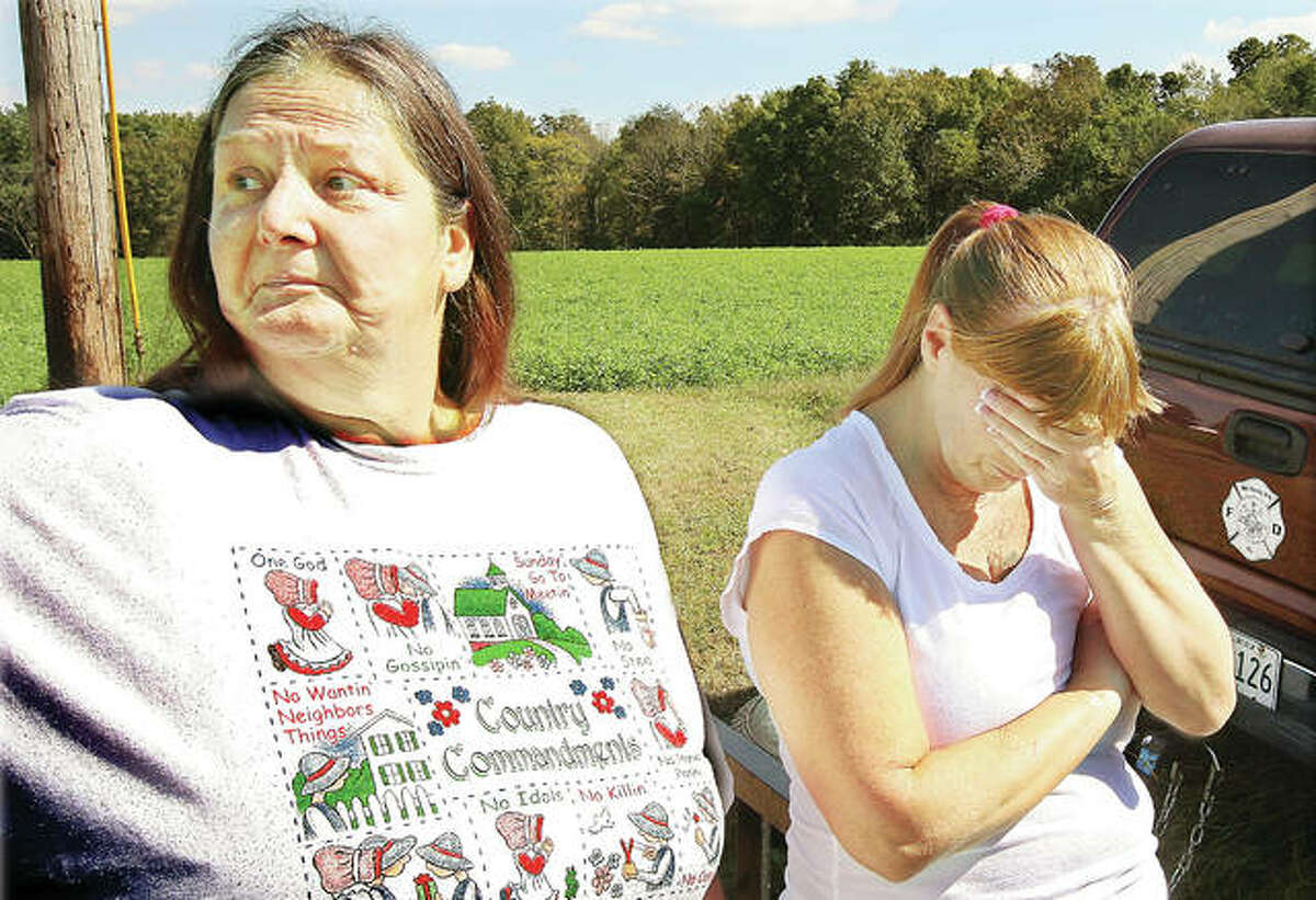The family of Bonnie Woodward has been waiting a long time for answers. In this photo taken in late September 2010, Linda Dean, left, and Bobbie Valdes, right, both sisters of Woodward, who at the time had been missing since June 25 of that year, react with emotion while they wait for word from the 80 law enforcement officers who were searching for her body around the home of Roger Carroll, then 44, on Creek Road east of Jerseyville.