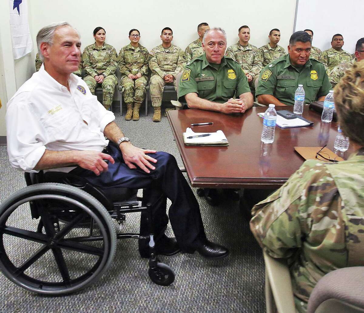 Gov. Greg Abbott, left, talks with leaders of the Texas National Guard and the Border Patrol at the Texas National Guard Armory on April 12 in Weslaco. Abbott announced that there will be an increase of 1,000 Texas National Guard on the southern border with Mexico.
