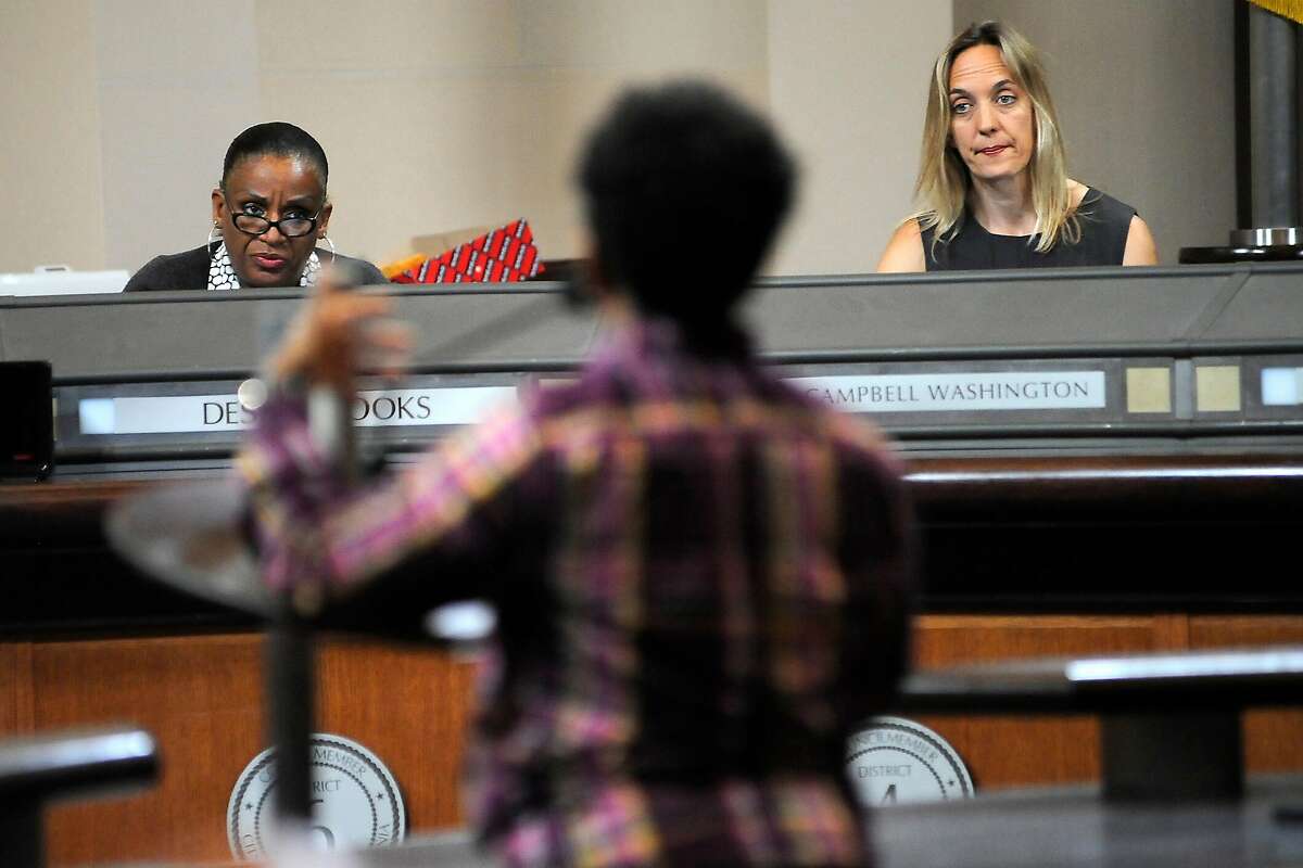 Council members Kelsey Brooks, left, and Annie Campbell Washington listen to public comments during an Oakland City Council held at City Hall in Oakland, CA Wednesday, July 7, 2015.