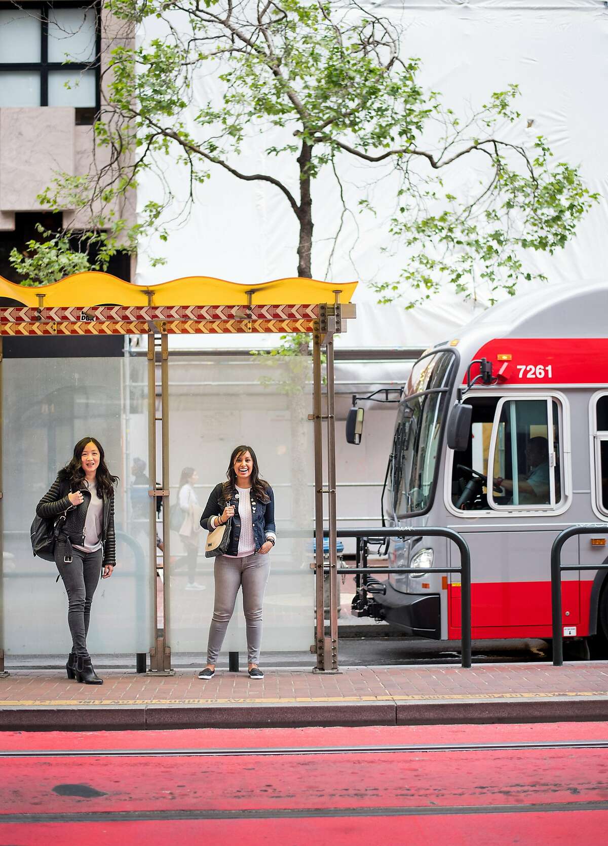 Muni Diaries co-founders Eugenia Chien, left, and Tara Ramroop stand at a Market St. bus stop on Monday, April 9, 2018, in San Francisco.