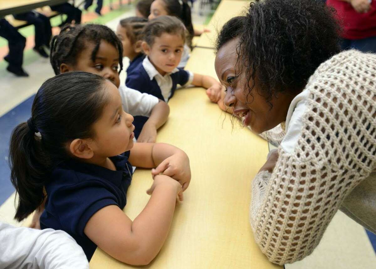 Designer Tracy Reese talks fashion with pre-k student Cassandra Santoyo Friday, Nov. 20, 2015, at Barnum School in Bridgeport, Conn. Reese was viting her adopted Turnaround Arts school to brainstorm with kids on a design project to enhance their school uniform.