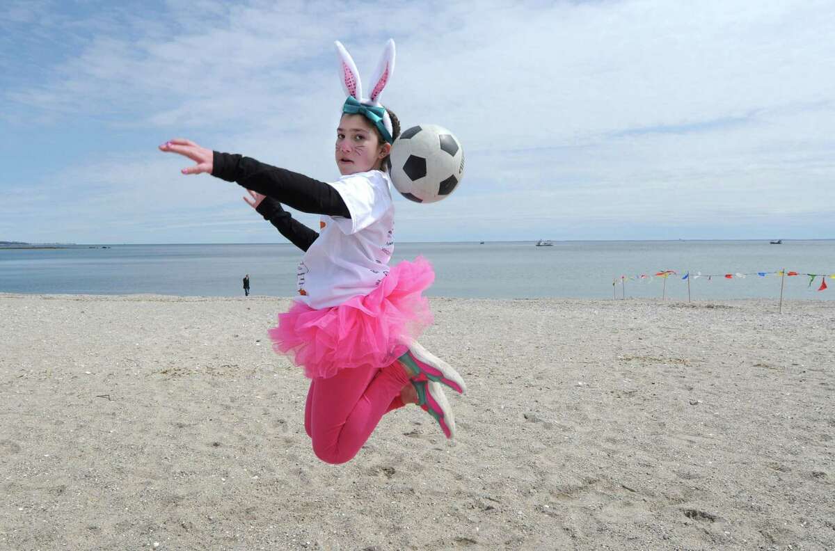 Olivia Fitch, 10, warms up with a soccer ball before the Special Olympics?’ 50th Anniversary and Penguin Plunge, Saturday, April 7, 2018, at Compo Beach in Westport , Conn.