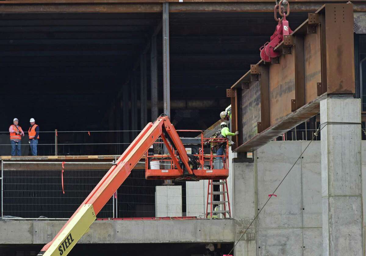 Construction workers with General Growth Properties put in place the huge steel beams that will form the span over North Water Street connecting the two structures of The SoNo Collection mall Friday, March 30, 2018, in Norwalk, Conn.