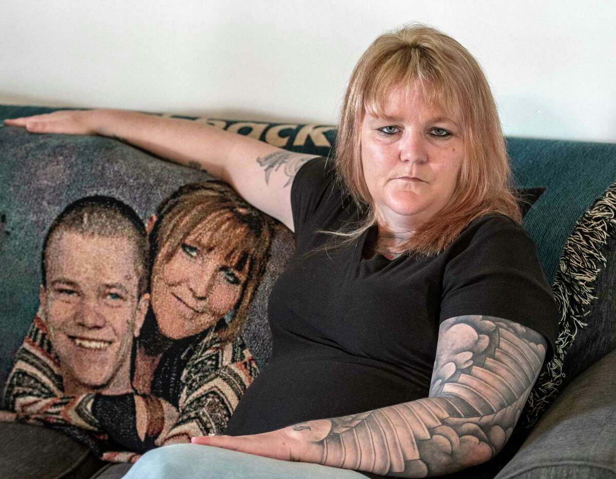 Tracy Minor sits on her couch at her home with a likeness of her son McKinley David Desnoyers on a blanket to her left Friday April 13, 2018 in Stillwater, N.Y. Her son died on Nov. 10, 2015 after an heroin overdose. (Skip Dickstein/Times Union)