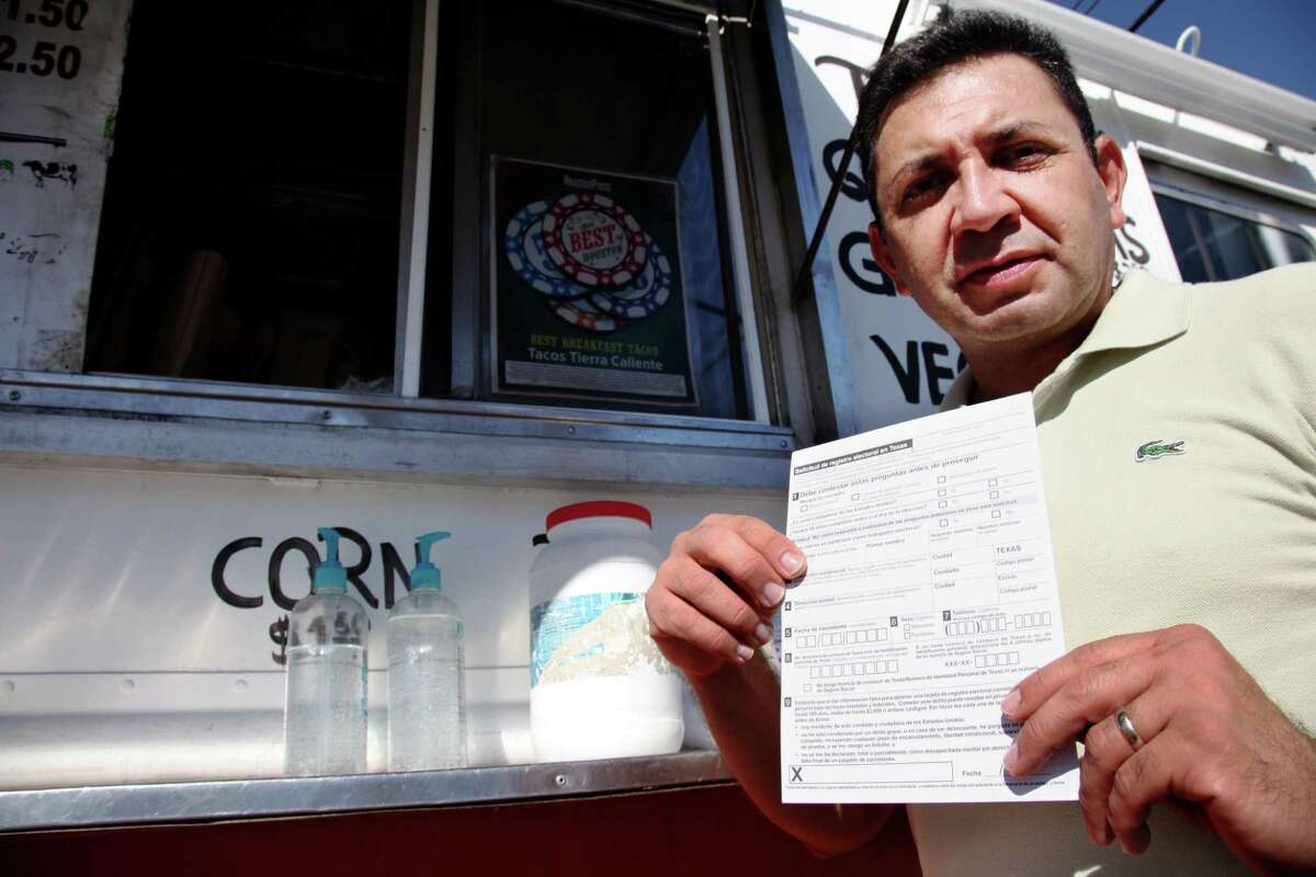Carlos Zamora shows a voter registration card from a pile placed on the counter of the Tierra Caliente taco truck on Thursday, Sept. 29, 2016, in Houston. Zamora is with Mi Familia Vota, a Latino activist group that seeks to register more voters in the Latino community. Mi Familia Vota partnered with a local design firm to make eight of the city's taco trucks into mobile voter registration booths after a surrogate of Republican presidential candidate Donald Trump recently suggested that unless the United States fortifies its borders and tightens immigration limits, "You're going to have taco trucks on every corner." (AP Photo/John L. Mone)