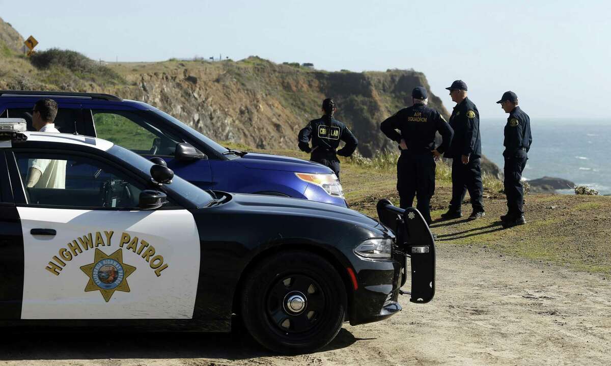 California Highway Patrol officers and deputy sheriffs from Mendocino and Alameda counties gather after a search for three missing children Wednesday, March 28, 2018, at the site where the bodies of Jennifer and Sarah Hart and three of their adopted children were recovered two days earlier, after the family's SUV plunged over a cliff at a pullout on the Pacific Coast Highway near Westport, Calif. Three of the children, Devonte Hart, 15, Hannah Hart, 16, and Sierra Hart, 12, have not been found. (Alvin Jornada/The Press Democrat via AP)