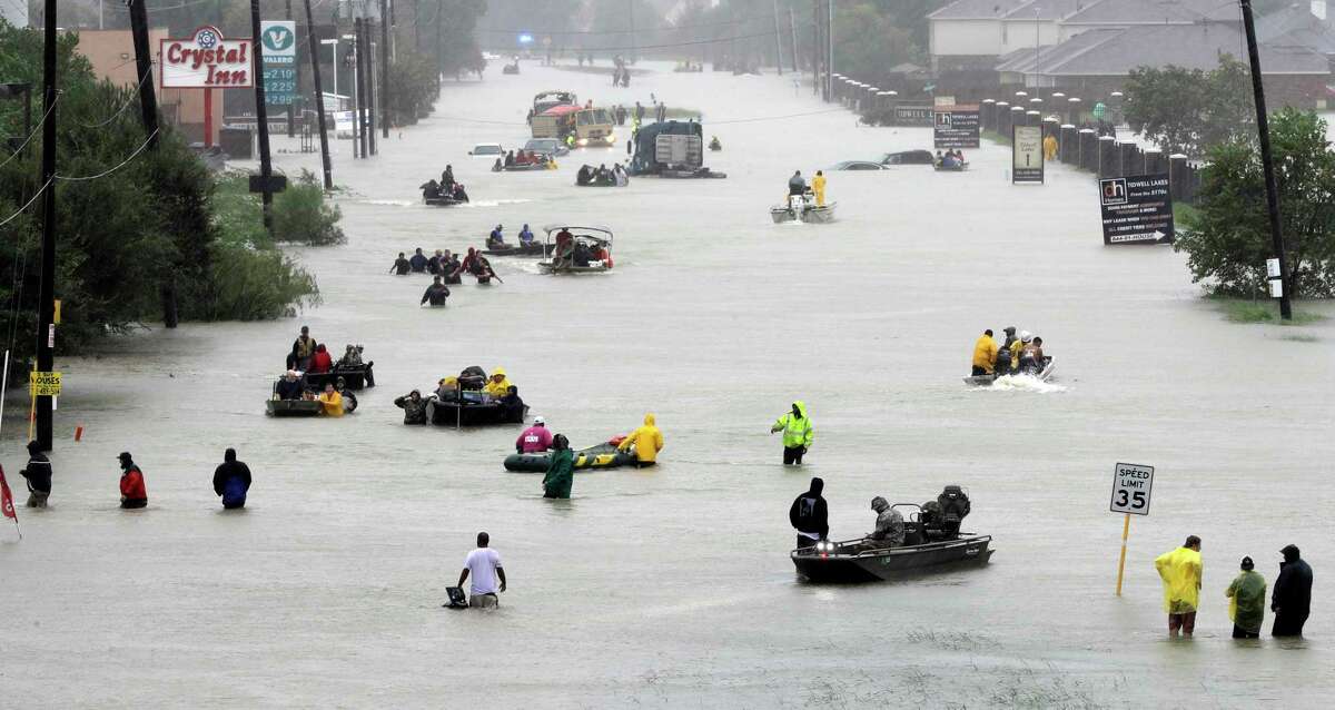 FILE - In this Aug. 28, 2017, file photo, rescue boats float on a flooded street as people are evacuated from rising floodwaters brought on by Tropical Storm Harvey in Houston. The National Hurricane Center’s official report on Harvey compiles staggering numbers, starting with 68 dead and $125 billion in damage. But the really big numbers in the Thursday, Jan. 25, 2018, tally have to do with the rainfall that swamped Houston. Two places had more than five feet of rain. Eighteen different parts of Texas logged more than four feet of rain. (AP Photo/David J. Phillip, File)