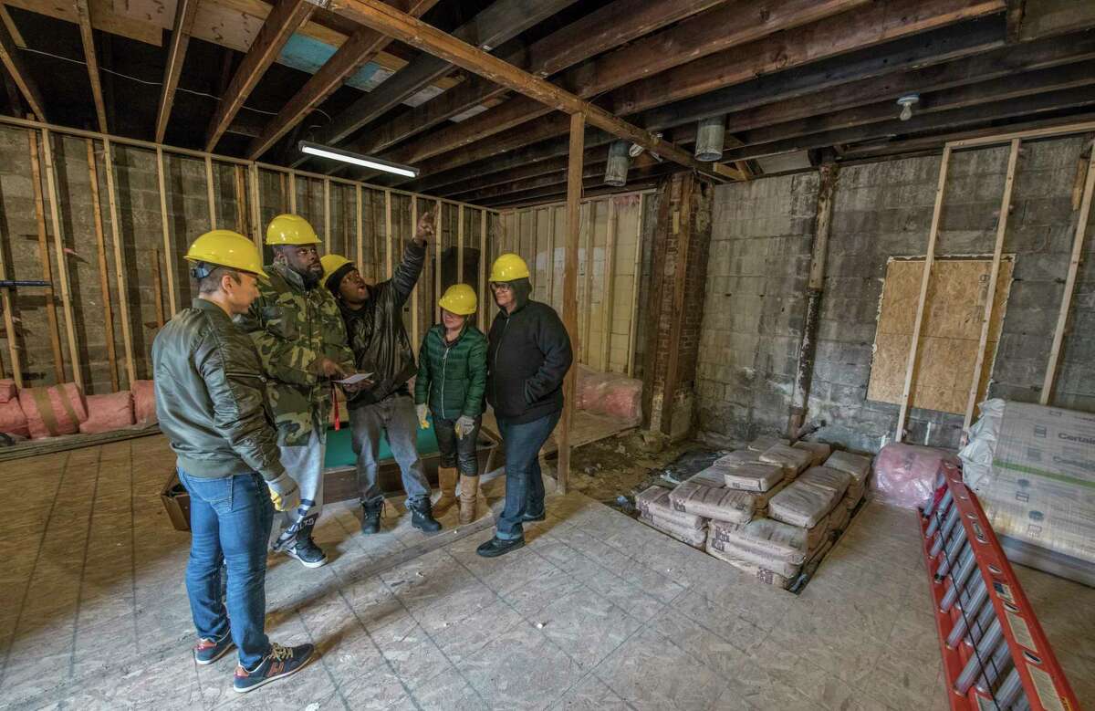 Workers (from left to right) Jie Ma, Benjamin Douglas, Carlyle Hannibal, Maggie Marinucci and Gurlene Bolton discuss the ongoing renovation that they are doing at 962 Vermont Avenue which is a building project underwritten by WIN or the Working in Neighborhood program putting welfare to work Friday April 13, 2018 in Schenectady, N.Y. (Skip Dickstein/Times Union)