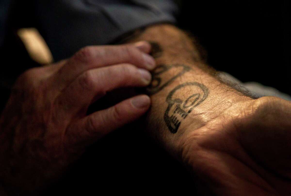 David Brown, a poet whose work is inspired by his time as a medic during the Vietnam War, feels five skulls which are tattooed on his forearm, Friday, April 6, 2018, in Houston. Each skull represents a close friend from his unit who was killed. "It feels good, it feels better than when they were just inside as memories," Brown said about his tattoos.