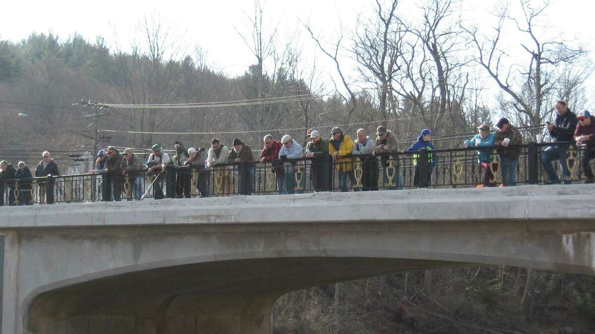 A crowd watches the fishing derby from the bridge above the Farmington River in Riverton on Saturday morning.