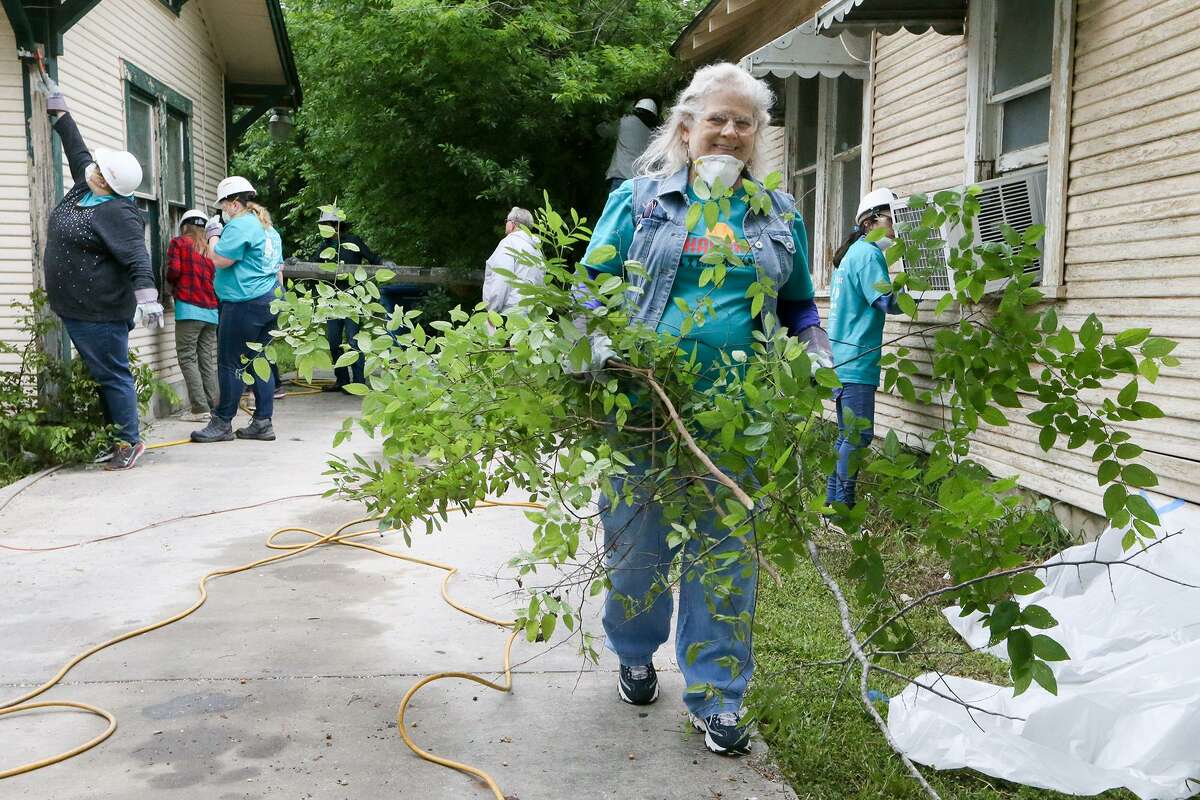 Terry Verner carries brush away from a home during the city's second annual Rehabarama in the Highland Park neighborhood on Saturday, April 7, 2018. Over three hundred volunteers gathered to help revive and revitalize twenty homes on E. Highland Blvd. with historic preservation in mind. MARVIN PFEIFFER/mpfeiffer@express-news.net