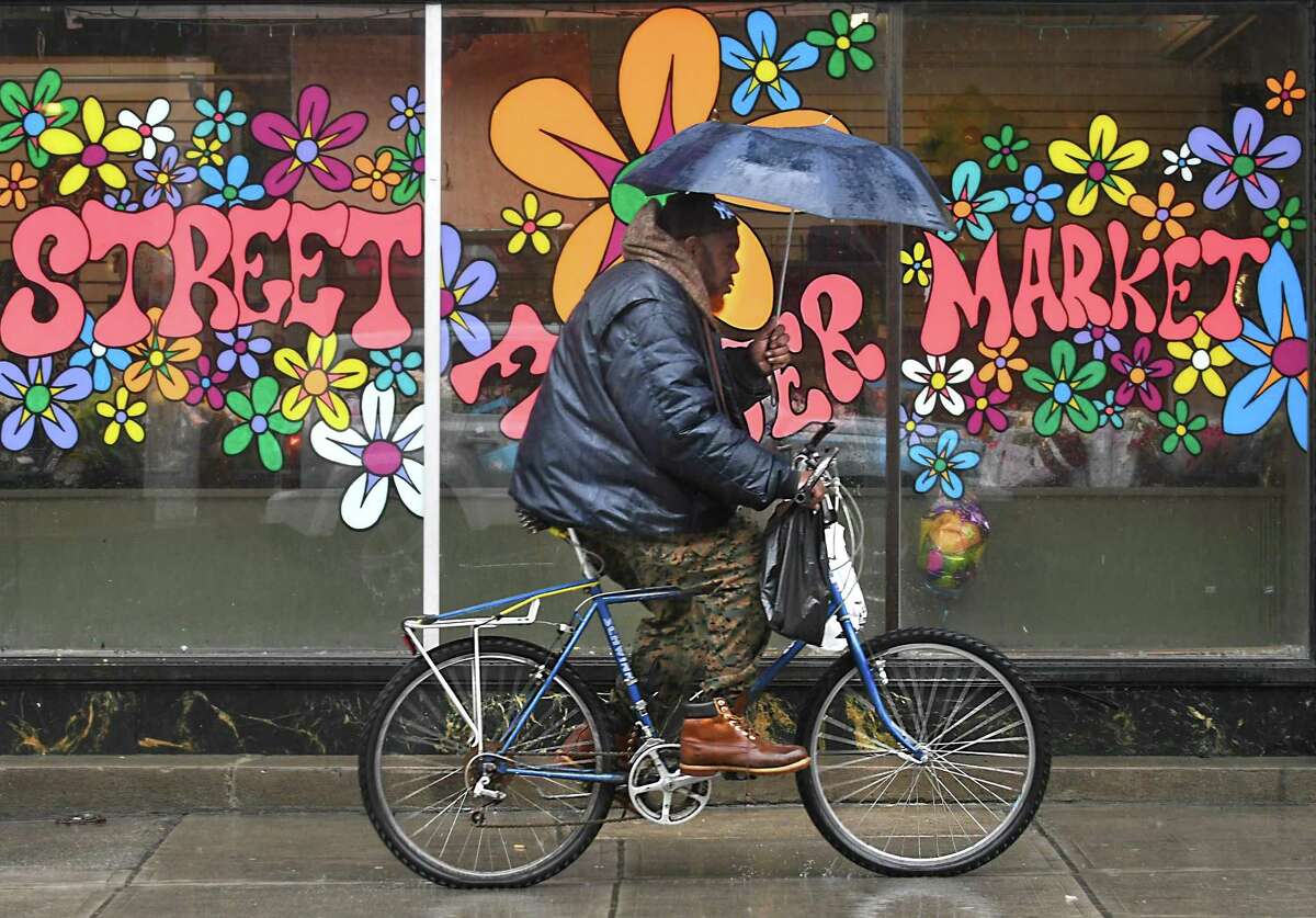 A bicyclist makes his way down Lark St. holding an umbrella during a rain storm on Monday, April 16, 2018 in Albany, N.Y. (Lori Van Buren/Times Union)