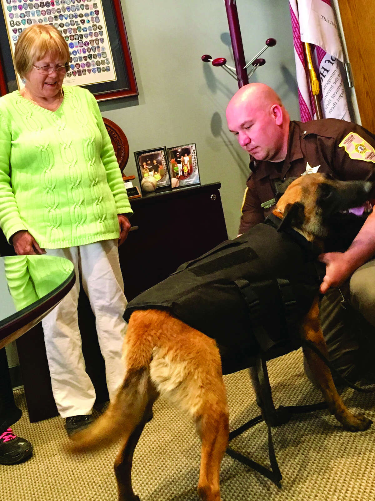 Madison County Sheriff’s Department K-9 Havoc models his bullett-proof vest for handler Deputy Kyle Doolen, right, and Barb Fry of the Mixed Breed Dog Club, which donated the item
