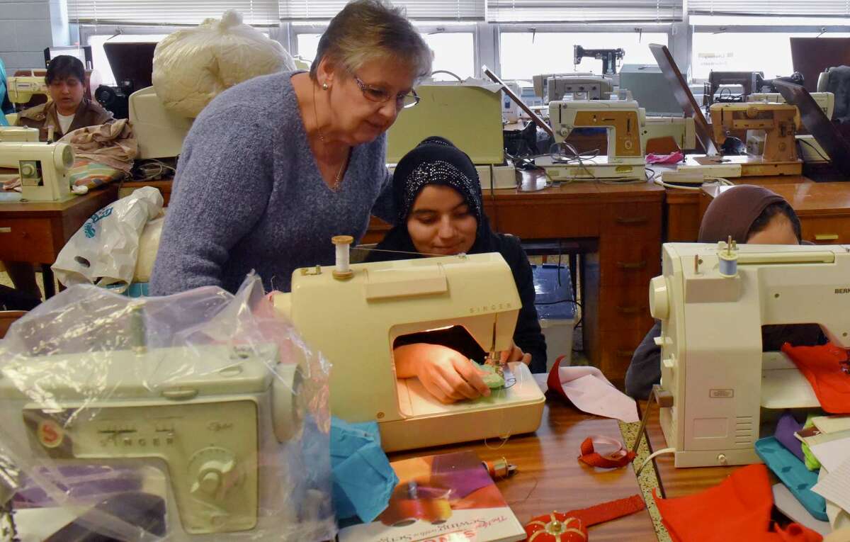 Mary Dwileski watches Fatima, a refugee from Afghanistan, as she practices her sewing skills on a square handkerchief at a class in Rensselaer's McManus Center on April 14, 2018. The class, sponsored by the Literacy Volunteers of Rensselaer County, takes place every Saturday to help refugees practice their sewing and English skills. (Massarah Mikati/Times Union)