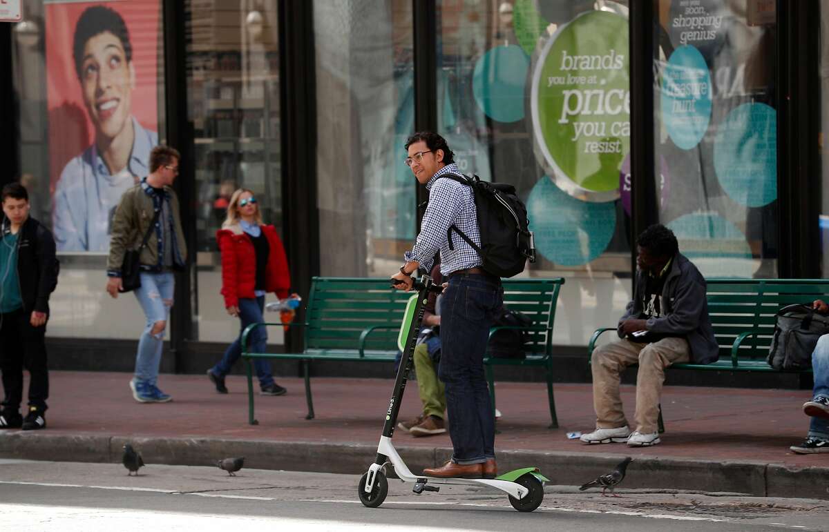 Cruising down Mission st. on a Lime scooter as seen on Mon. April 9, 2018, in San Francisco, Calif.