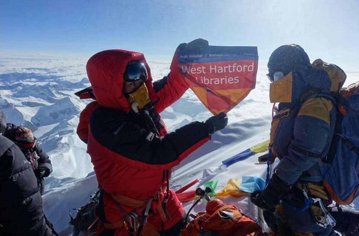 In this May 2017 photo provided by Lhakpa Sherpa, Sherpa displays a flag from West Hartford, Conn., on the summit of Mount Everest in Nepal. Once a year, Sherpa heads back to her native Nepal to try and break her own record for successful summits of Mount Everest by a woman. (Courtesy of Lhakpa Sherpa via AP)