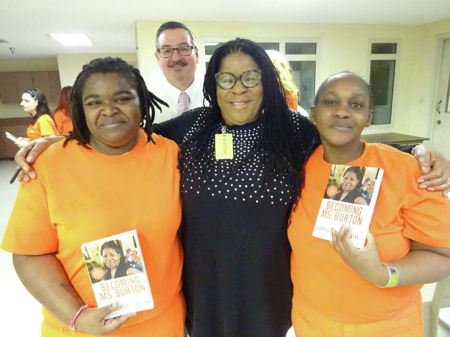 Sade Faulks, left, and Keatinas Neeley hold their signed books by author Susan Burton, center, during her visit to the Albany County Jail as Theron Rockwell, the jail's director of services, looks on from behind.