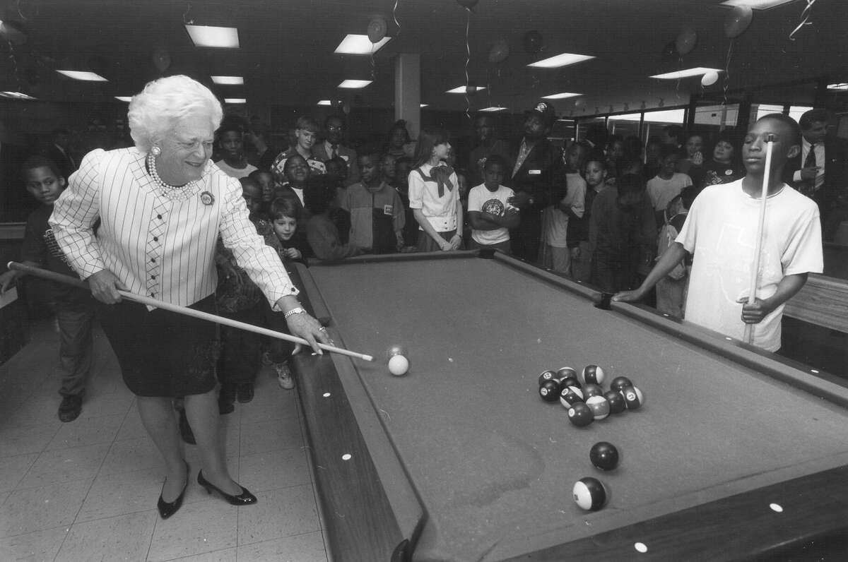 First Lady Barbara Bush plays pool with 12-year-old Tyrone Darden at the East Branch of the Boys & Girls Clubs of San Antonio on Feb. 26, 1992. Tyrone said later he thought he was playing with Texas Gov. Ann Richards. San Antonio Express-News file photo
