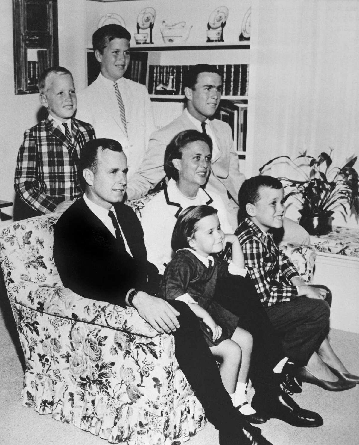 FILE - In this 1964 file photo, George H.W. Bush sits on couch with his wife, Barbara, and their children. George W. Bush sits at right behind his mother. Behind couch are Neil and Jeb Bush. Sitting with parents are Dorothy and Marvin Bush. A family spokesman said Tuesday, April 17, 2018, that former first lady Barbara Bush has died at the age of 92. (AP Photo/File)