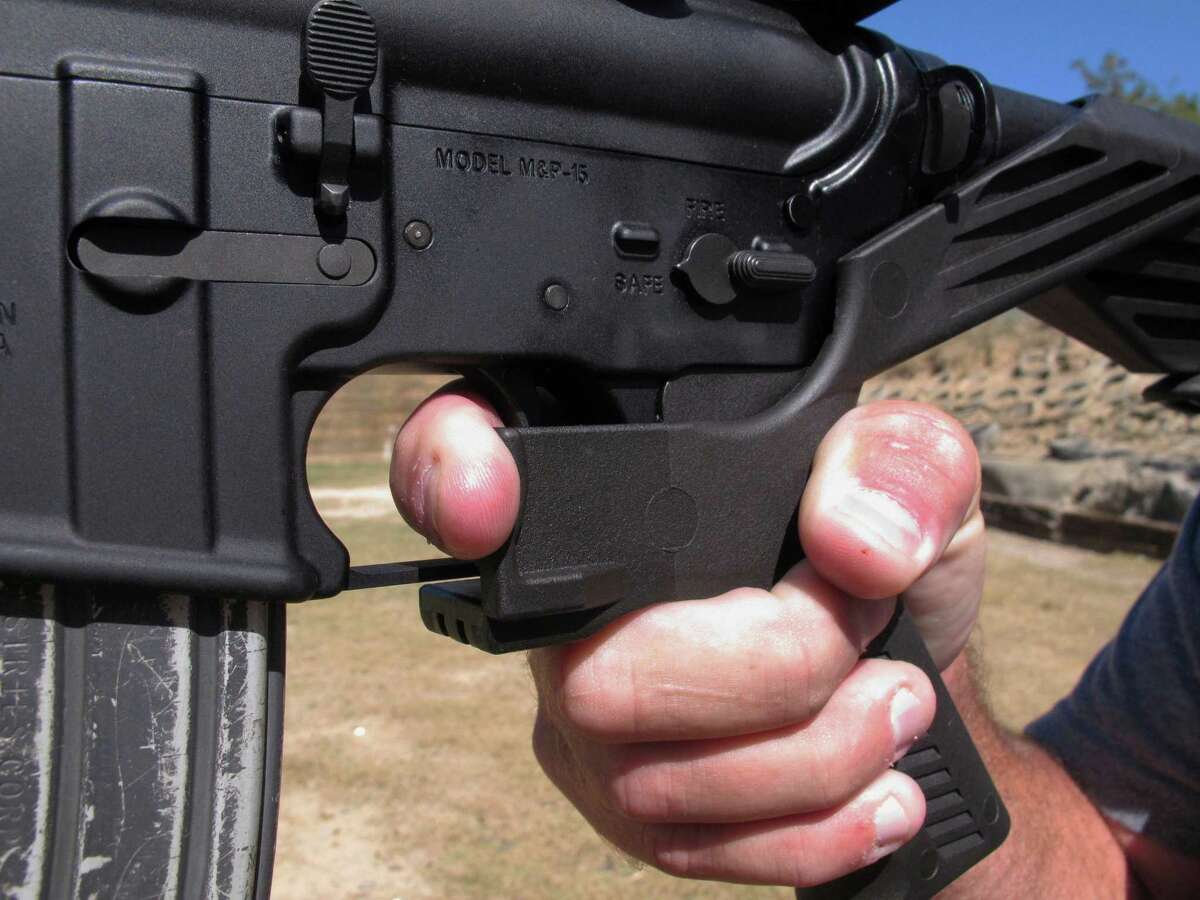 In this Oct. 4, 2017, photo, shooting instructor Frankie McRae demonstrates the grip on an AR-15 rifle fitted with a "bump stock" at his 37 PSR Gun Club in Bunnlevel, N.C. The largest manufacturer of bump stocks, which allow semi-automatic weapons to fire rapidly like automatic firearms, announced Wednesday, April 18, 2018, that it will stop taking orders and shut down its website next month.