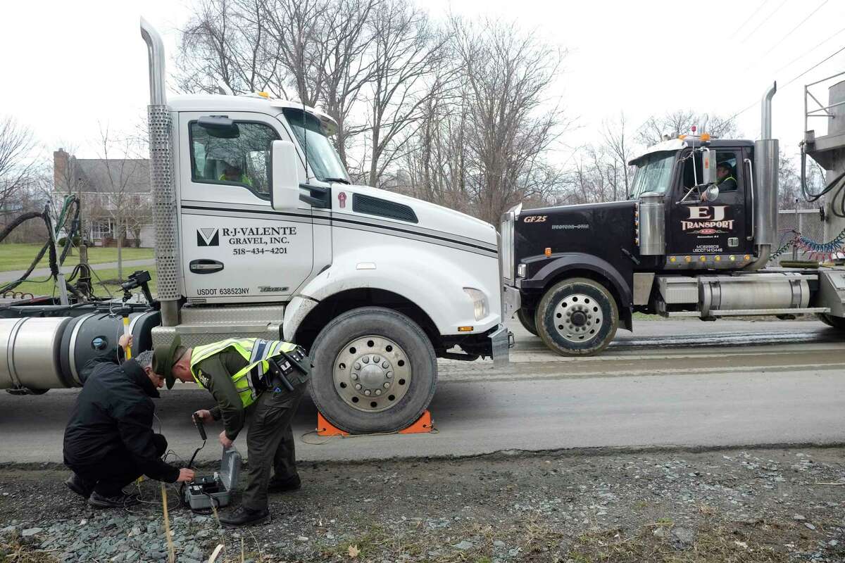 Environmental engineer, Gary McPherson, left, with the New York State Department of Environmental Conservation, and NYSDEC Police Officer, Brian Canzeri, set up equipment to perform an emissions test on a truck at a checkpoint outside the Dunn construction and demolition debris landfill on Wednesday, April 18, 2018, in Rensselaer, N.Y. (Paul Buckowski/Times Union)