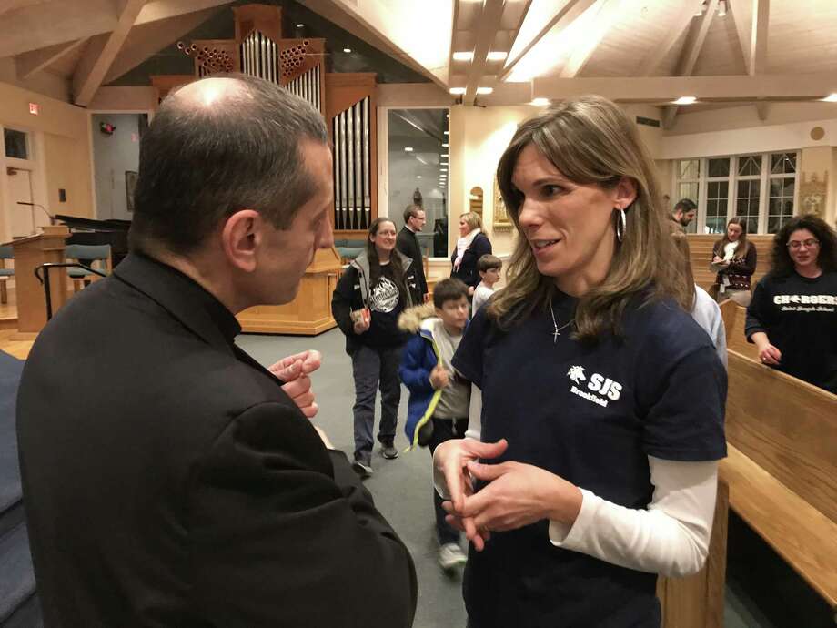 Bishop Frank Caggiano speaks with Jen Conlon, who is on the Home School Association at St. Joseph's School in Brookfield. Caggiano has proposed changing the educational model at St. Josephs. Caggiano and Steve Cheeseman, superintendent of the Diocese of Bridgeport Catholic schools, made the announcement at the parish Thursday night, January 18, 2018. Photo: Contributed Photo/ Diocese Of Bridgeport / Hearst Connecticut Media / The News-Times Contributed