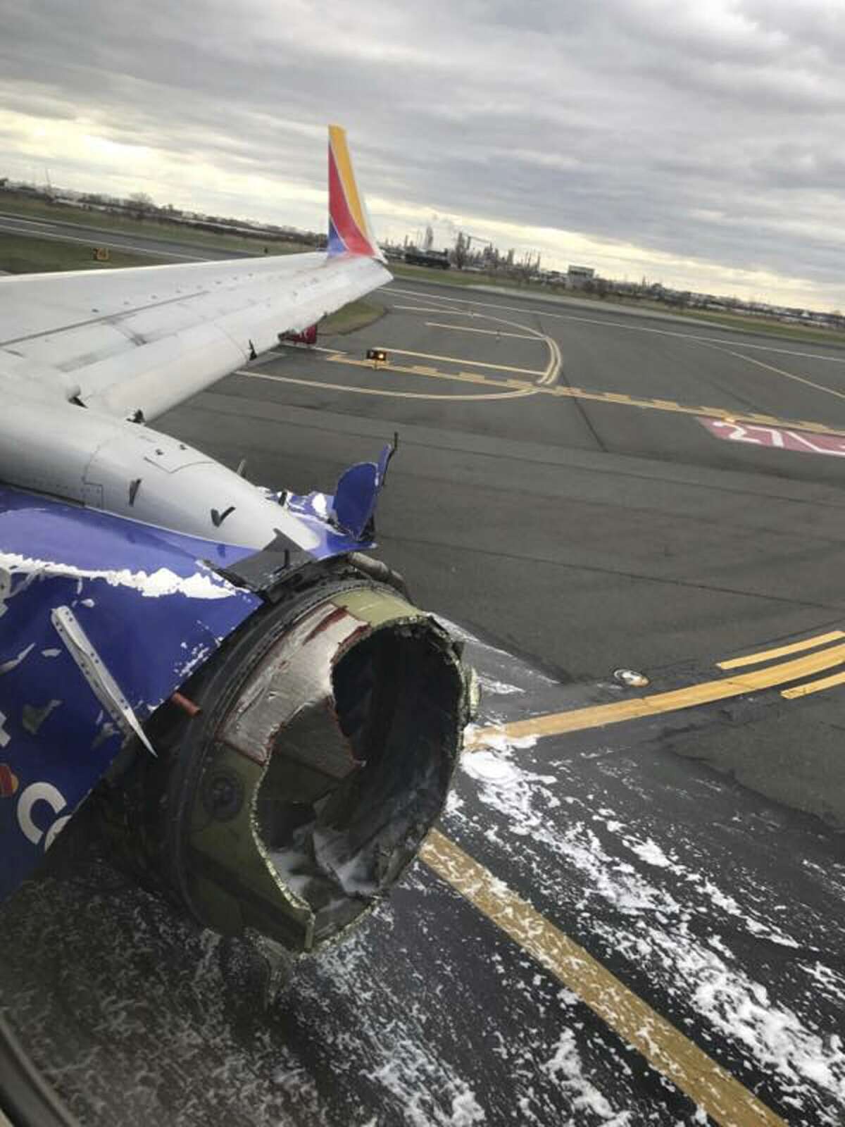 This April 17, 2018 photo provided by Marty Martinez shows the jet engine casing of a Southwest Airlines airplane Martinez was a passenger on after pilots of the twin-engine Boeing 737 bound from New York to Dallas with 149 people aboard took it into a rapid descent and made an emergency landing in Philadelphia. A preliminary examination of the engine showed evidence of "metal fatigue," according to the National Transportation Safety Board. (Marty Martinez via AP)