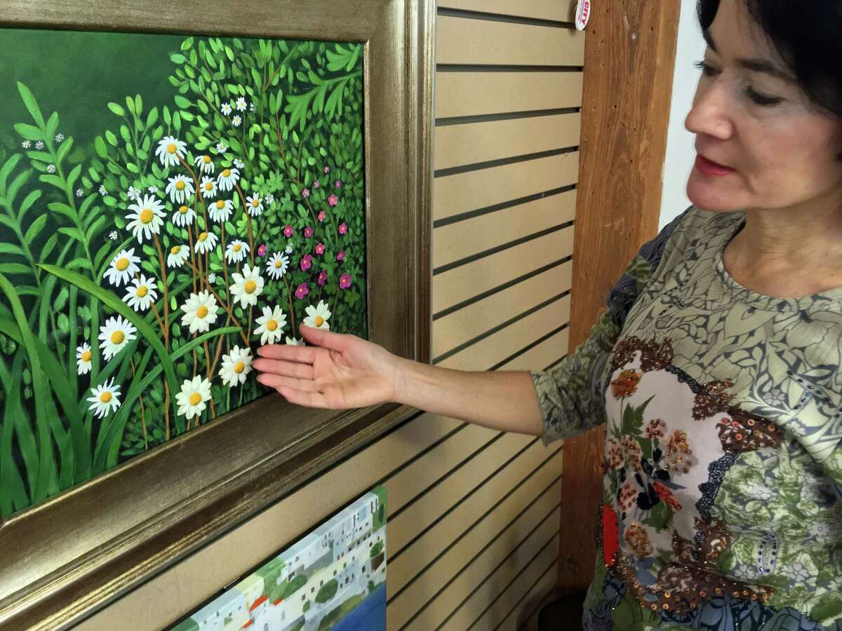 Rosa Colon, a Stamford, Connecticut, artist, points out her porcelain work on canvas during a visit to her studio at the Loft Artists Association in Stamford on April 11, 2018.
