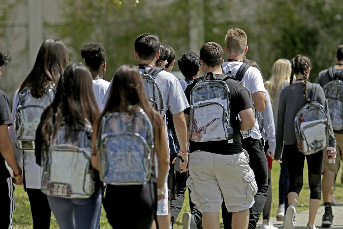 Students wear clear backpacks outside of Marjory Stoneman Douglas High School in Parkland, Fla., on Monday, April 2, 2018. The bags are one of a number of security measures the school district has enacted as a result of the Feb. 14 shooting at the school that killed 17. (John McCall/South Florida Sun-Sentinel via AP)