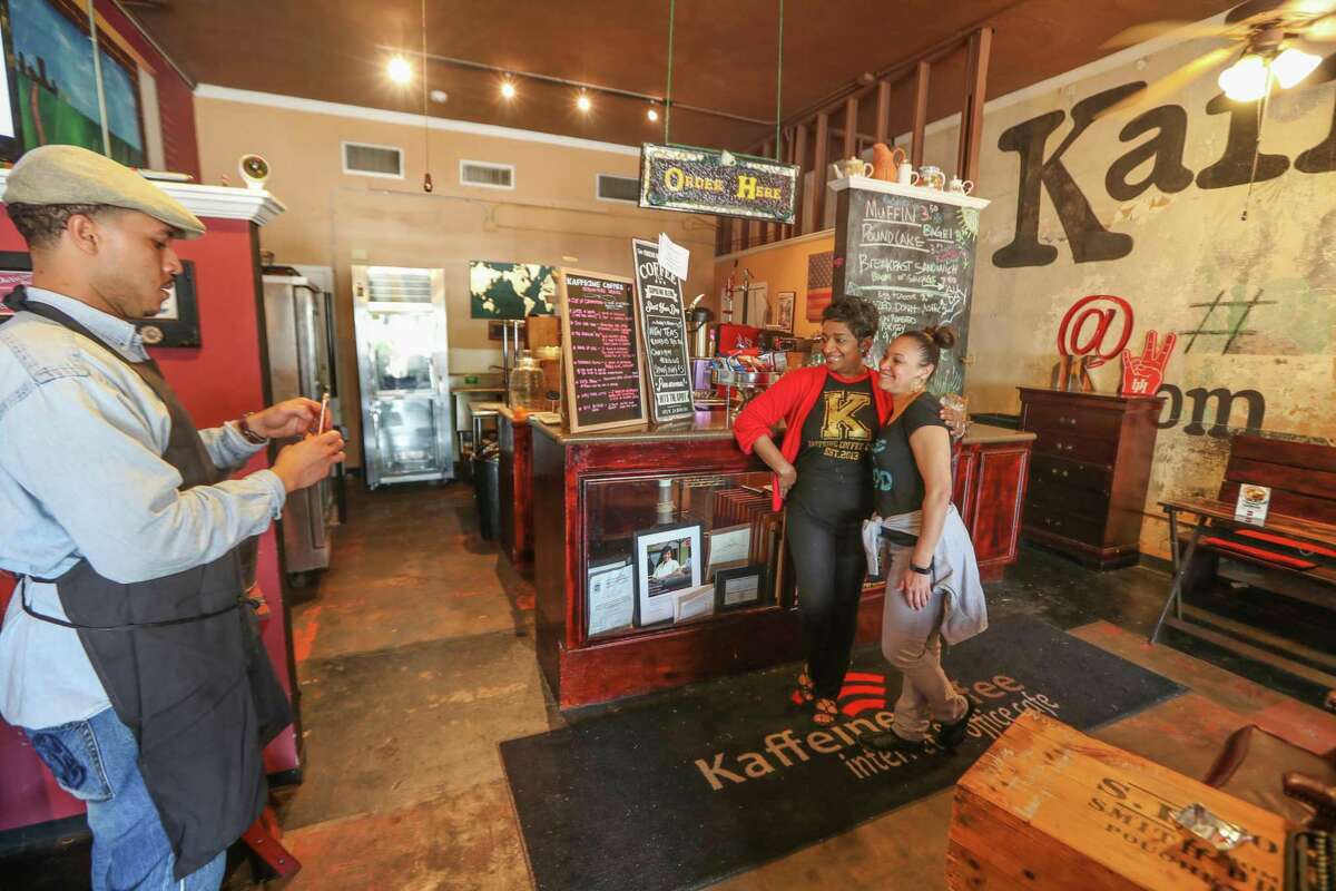 Kaffeine Coffee Chef Donovan Blake (left) shoots photo of Andrea Guillory (right) and owner Orgena Keener Wednesday, April 18, 2018, in Houston. Andrea Guillory traveled from Pearland to support Kaffeine Coffee, a black-owned coffee shop in the Third Ward that has seen a boost in sales after two black men were arrested at a Starbucks in Philadelphia for waiting on a friend.( Steve Gonzales / Houston Chronicle )