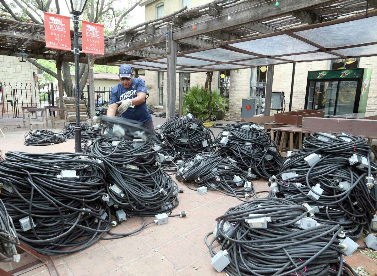 Hank Cortez deals with wires Wednesday, April 18, 2018 of some of the many temporary electrical circuits being installed on the La Villita grounds for A Night in Old San Antonio which runs April 24-27.