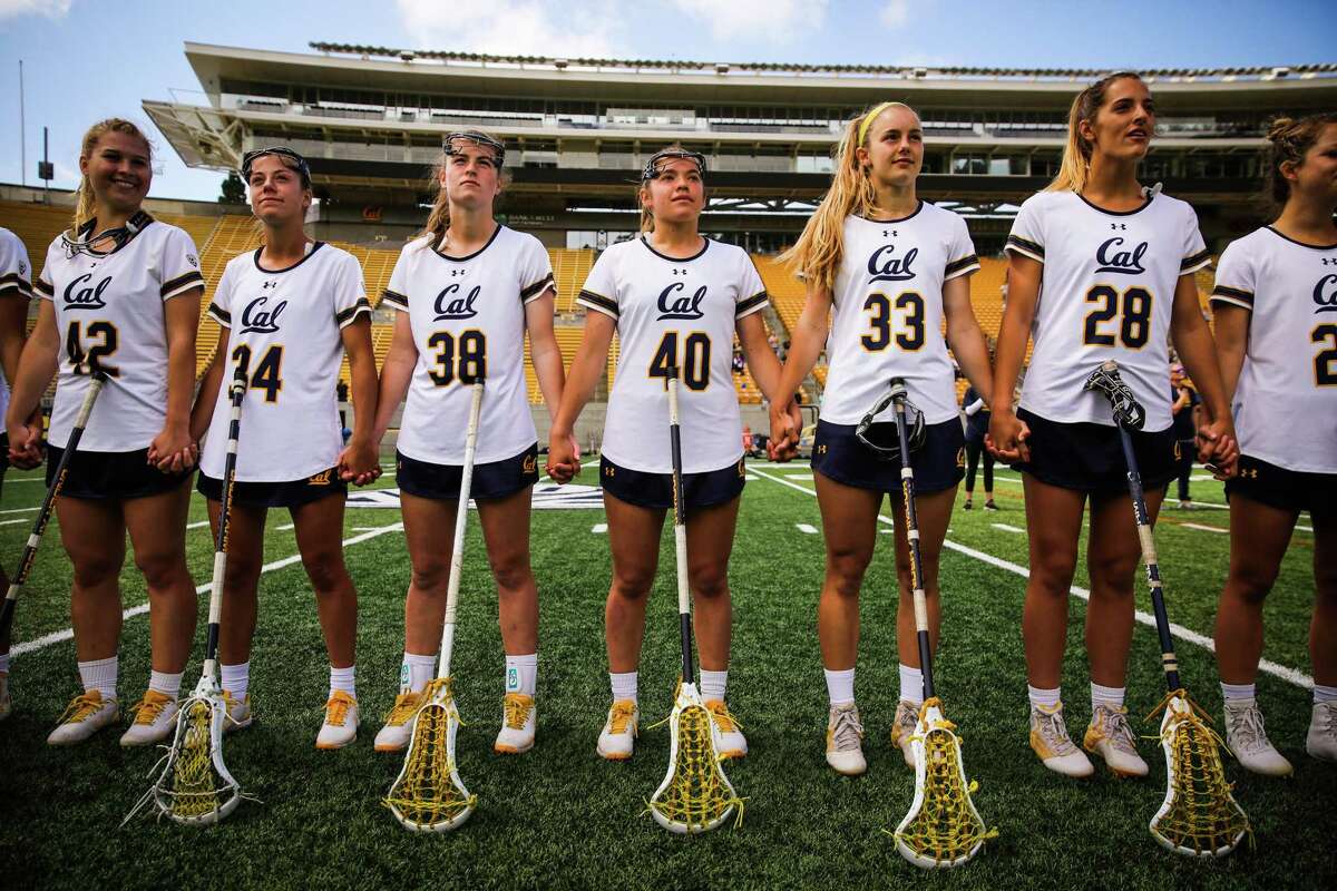 Cal women's lacrosse player Ashley Ward (40) (center) links hands with her teammates ahead of a lacrosse game between Cal and Colorado at California Memorial Stadium in Berkeley, California, on Sunday, April 15, 2018.
