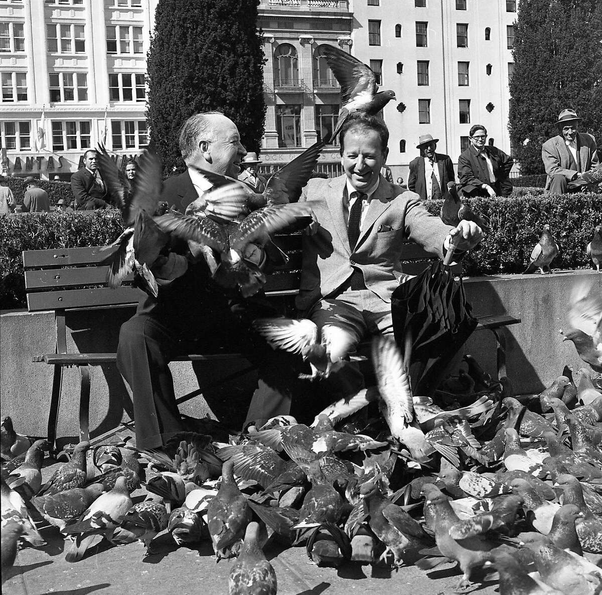 1963年4月1日:赫伯·卡恩和阿尔弗雷德·希区柯克在联合广场开心地谈论希区柯克的新电影《群鸟》。