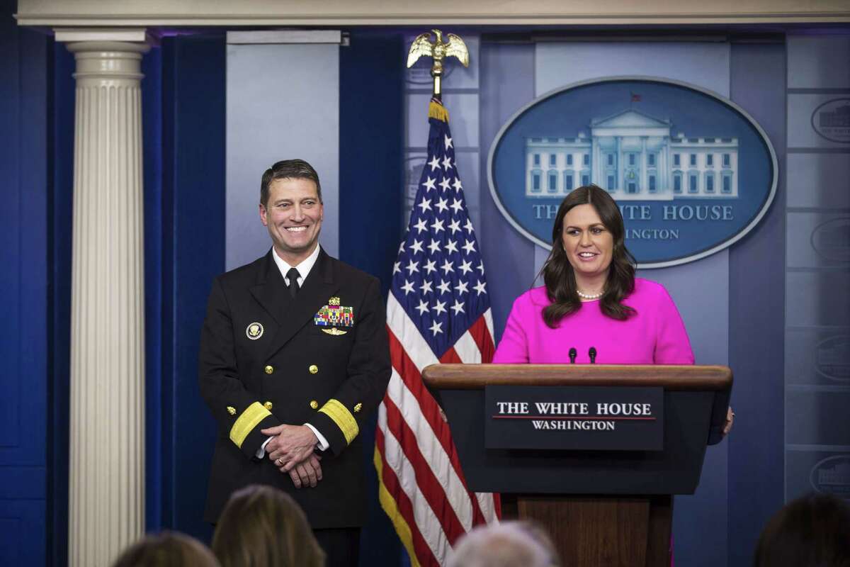 Sarah Huckabee Sanders, White House press secretary, speaks to members of the media while Ronny Jackson (left), physician for President Donald Trump, smiles during a White House press briefing in Washington on Jan. 16, 2018.