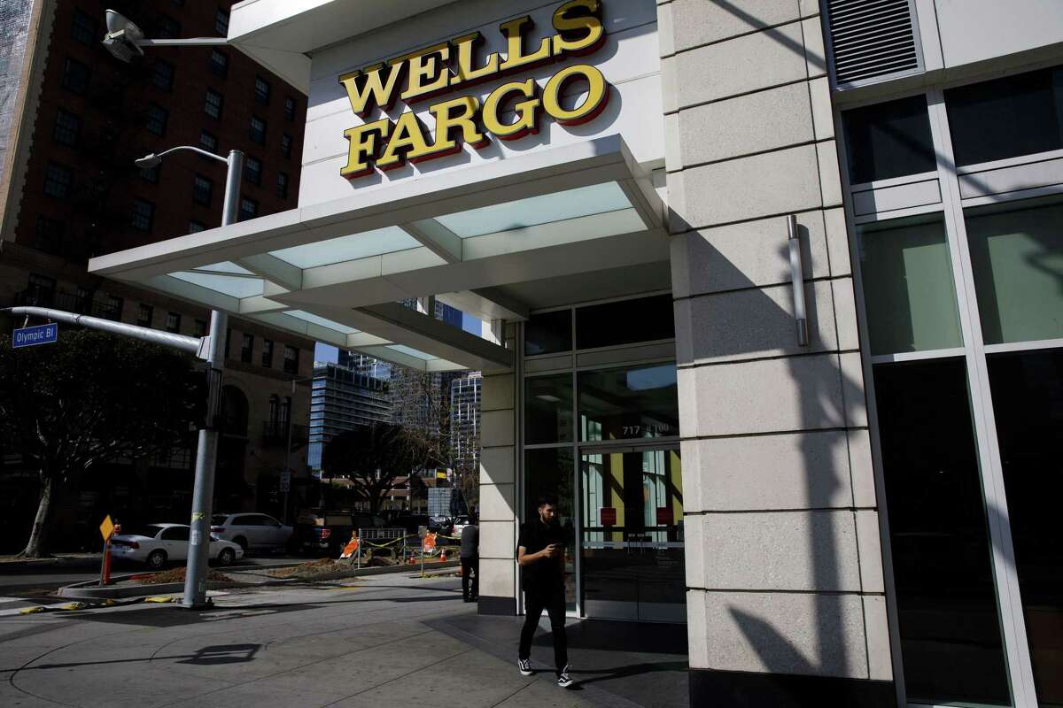 Pedestrians walk past a Wells Fargo & Co. bank branch in Los Angeles on April 19, 2018.