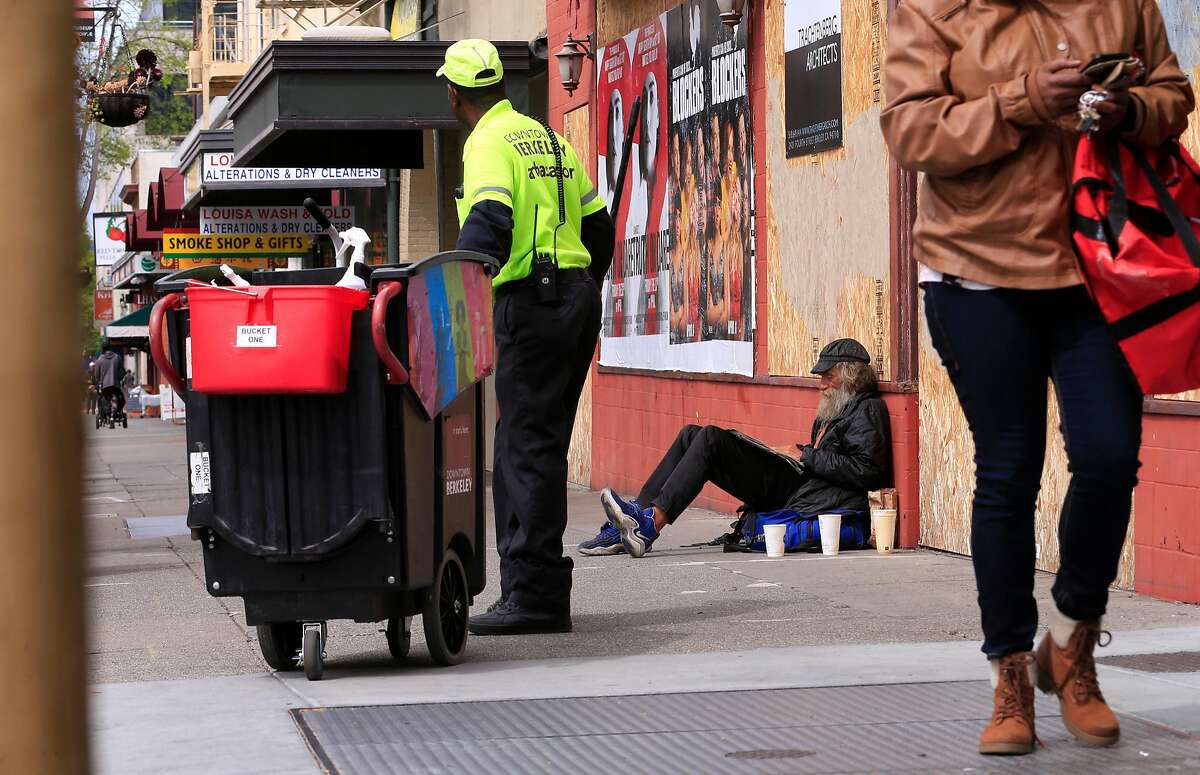 Berkeley ambassador Ernest Watson, (left) cleans the sidewalks as Tu (didn't give his last name) who is homeless says he would miss the paper cups he uses for his coffee and to panhandle with along University Ave. in Berkeley, Calif., as seen on Wed. April 18, 2018. A proposal is underway in Berkeley that would try to eliminate nearly all single-use coffee cups and take-out food containers.