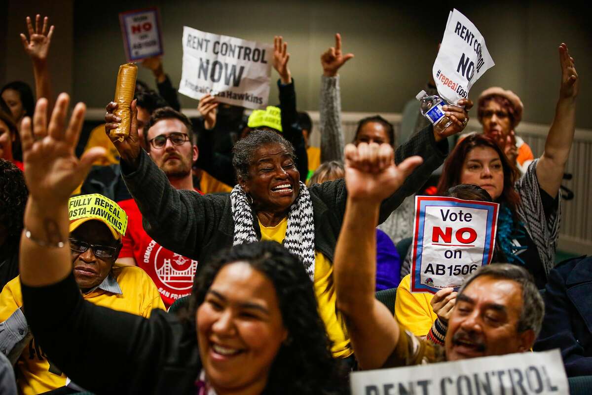 Bonbon Hurd (center), Yesenia Miranda Meza (bottom left), and Jose Diaz (bottom right) put their hands up in excitement during the public comment portion of a hearing on whether or not to repeal the Costa-Hawkins Rental Housing Act at the State Capital in Sacramento, Calif., on Thursday, Jan. 11, 2018. The Costa-Hawkins Rental Housing Act did not pass.