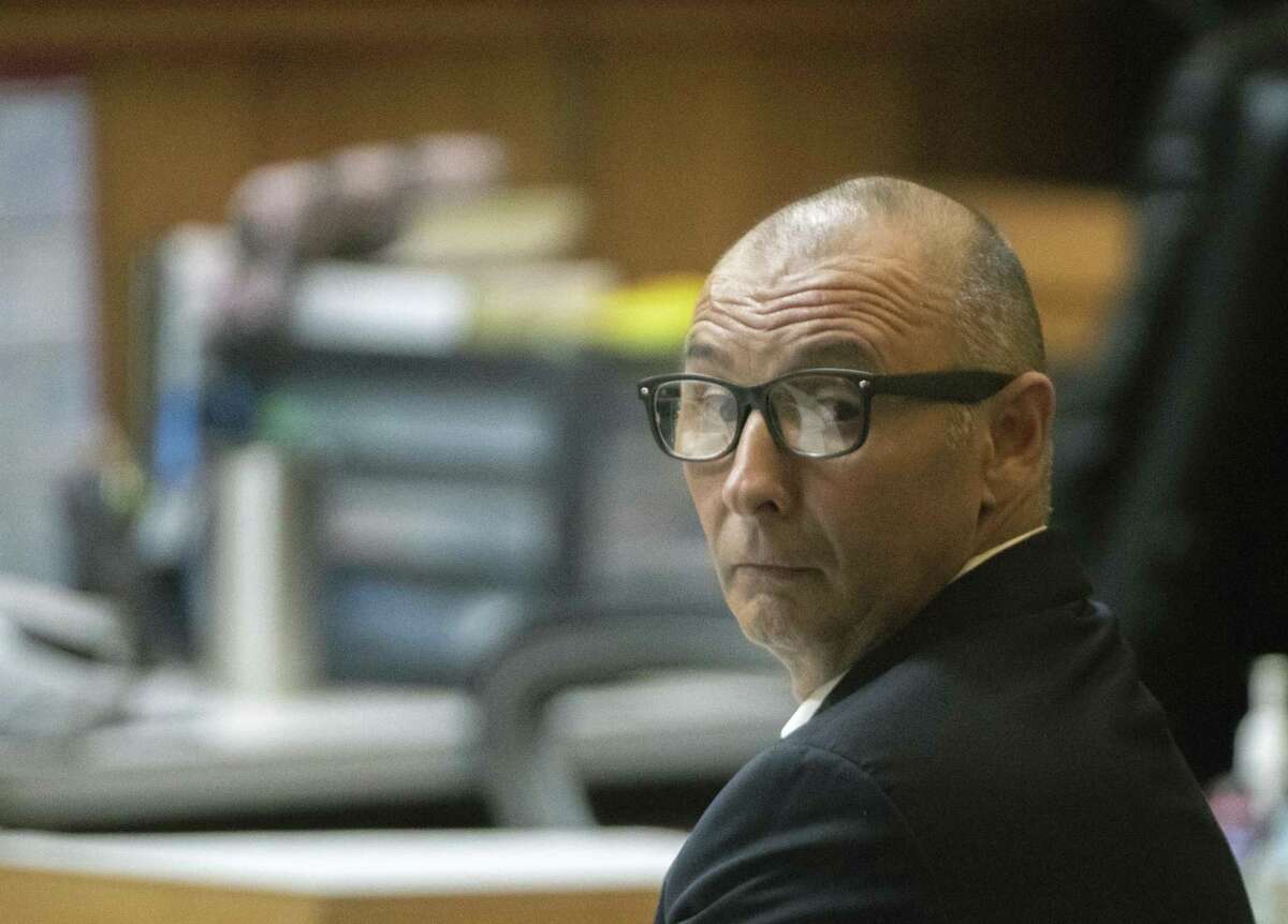 Defendant Gilberto Escamilla looks back before the start of a sentencing hearing Friday, April 20, 2018, in the 107th state District Courtroom in Brownsville, Texas. Escamilla entered two pleas of guilty for charges related to the theft of over 1-million dollars of meats he stole and resold over two years through his position with Cameron County. (Jason Hoekema/The Brownsville Herald via AP)