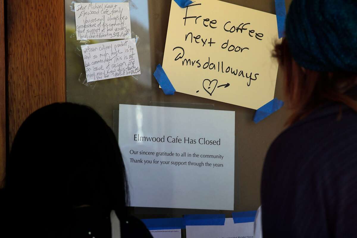 People gather the front door of the Elmwood Cafe on College Ave. to read the sign about the sudden closure of the Cafe as seen on Fri. April 20, 2018, in Berkeley, Calif.