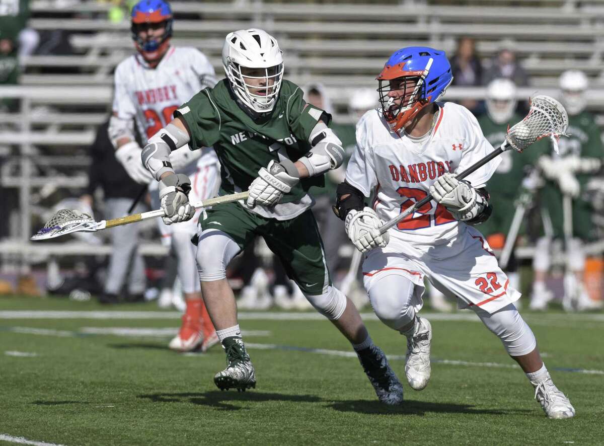 Danbury's Marson Rivers (22) is shadowed by New Milford's Jacob Anderson (1) as he moves with the ball in the boys lacrosse game between New Milford and Danbury high schools, Friday, April 20, 2018, at Danbury High School, in Danbury, Conn.
