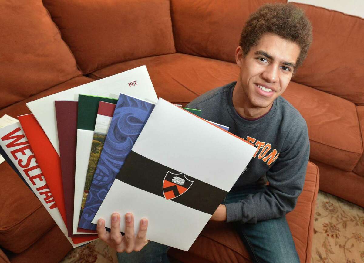 Chaz Bethel-Brescia fans out the college folders with letters of acceptance on Tuesday April 17, 2018 in Norwalk Conn. Chaz was accepted to four ivy league schools and MIT, his senior essay was about his experience being raised by two mothers.